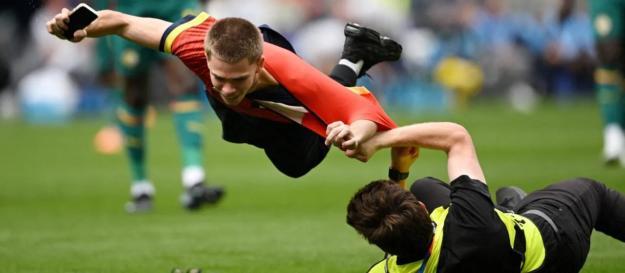 Ein Flitzer (l.) wird beim Belgien-Spiel gestellt